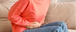 woman holding her stomach in distress