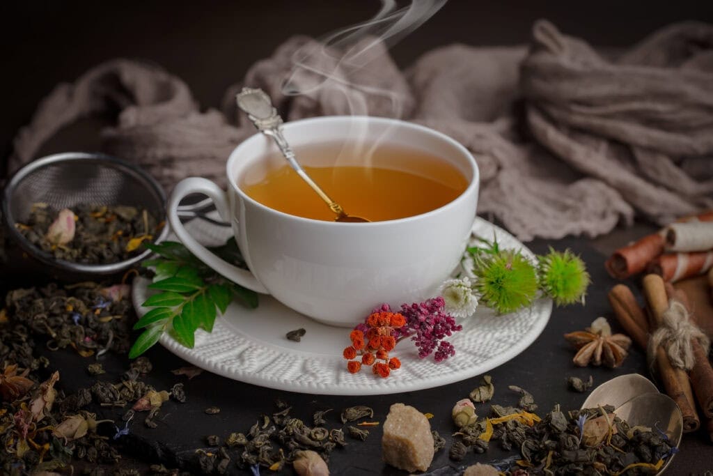 A steaming cup of herbal tea in a white ceramic cup.
