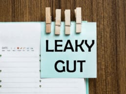 Leaky Gut written on a Post-It note that's pinned to a diary with clothes pegs