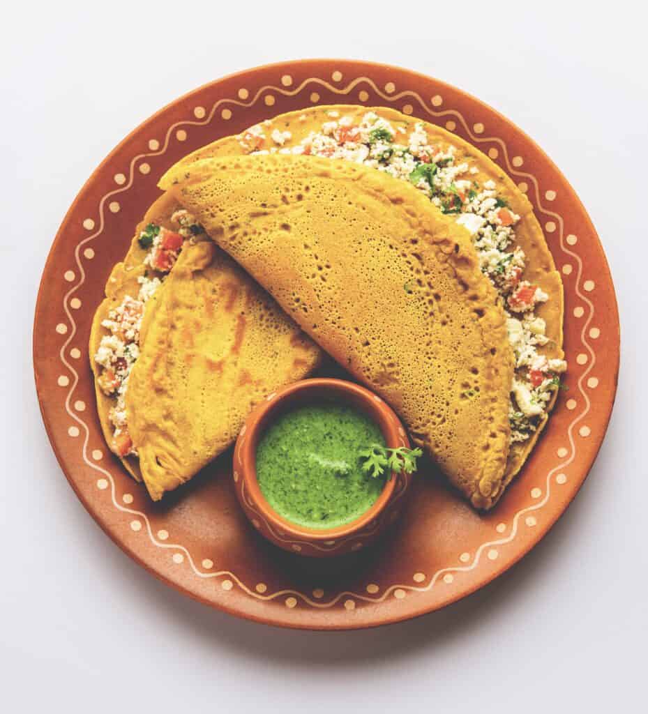 Moong dal chilla with paneer stuffing and coriander and mint dip on the side.
