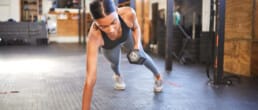 A woman working out with weights in a gym