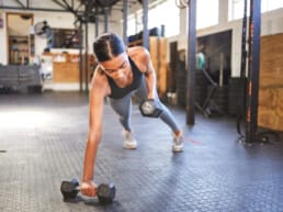 A woman working out with weights in a gym